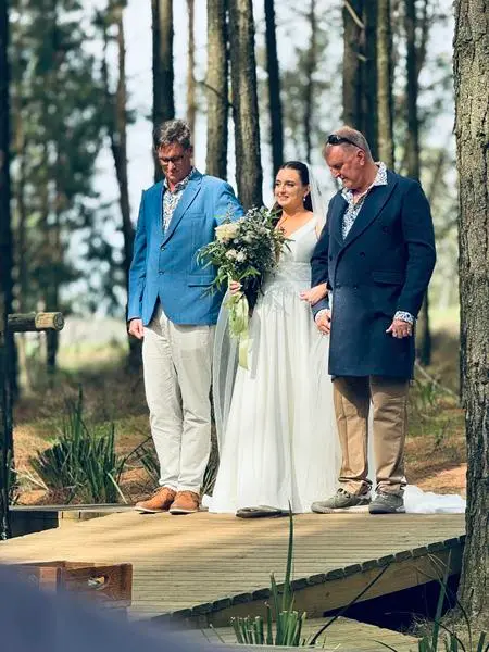 The bride and groom on the wooden deck among the pine trees at Haycroft Farm
