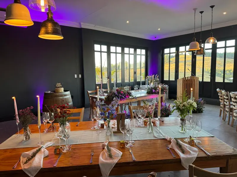 Purple uplighting over the decorated tables in the Oasis Venue at Brahman Hills