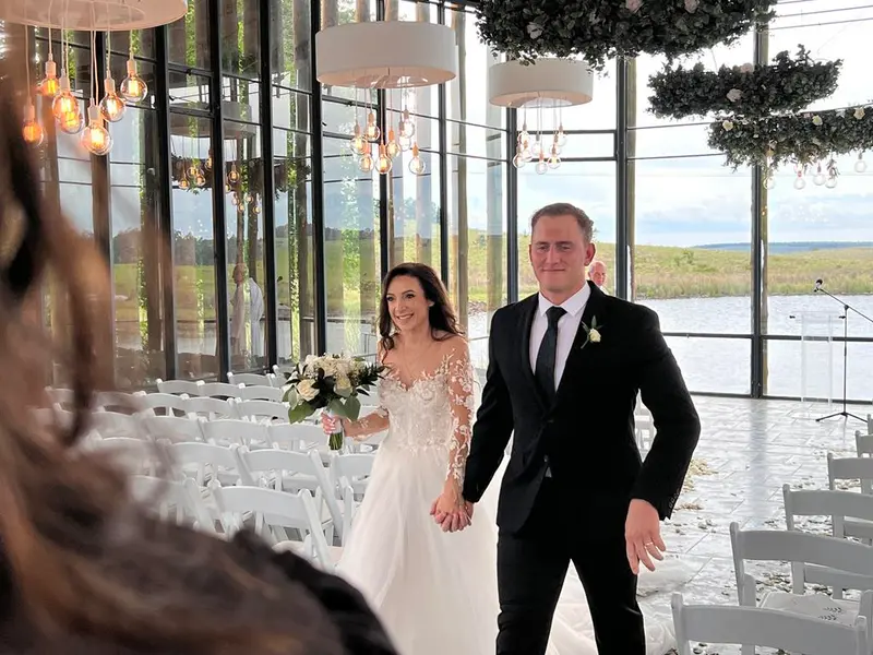 A bride and groom walking into their reception at Brahman Hills