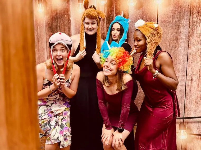 Wedding guests posing with photobooth props and party hats