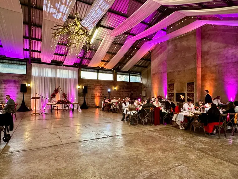 Reception in a stone and timber hall with purple venue uplighting