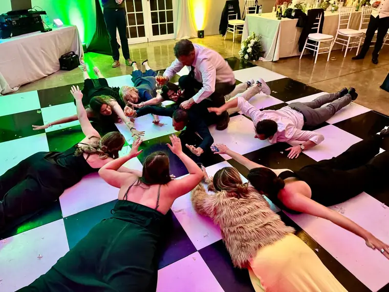 Guests on a checkerboard dancefloor during a group dance