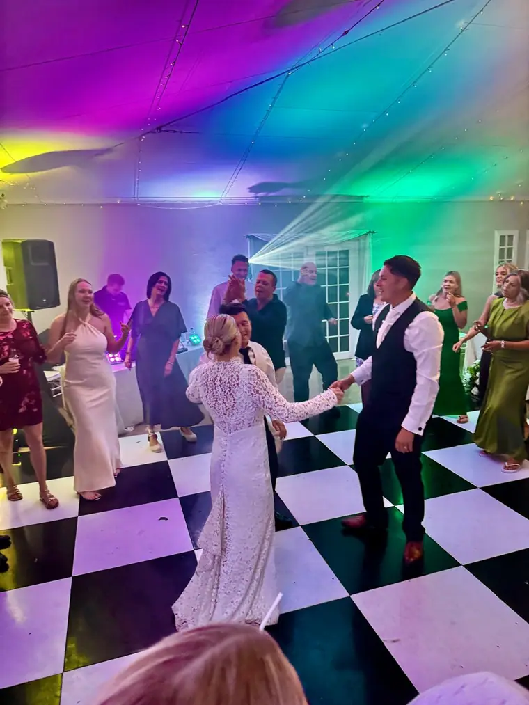 Dancing on a checkerboard floor under green and pink lighting