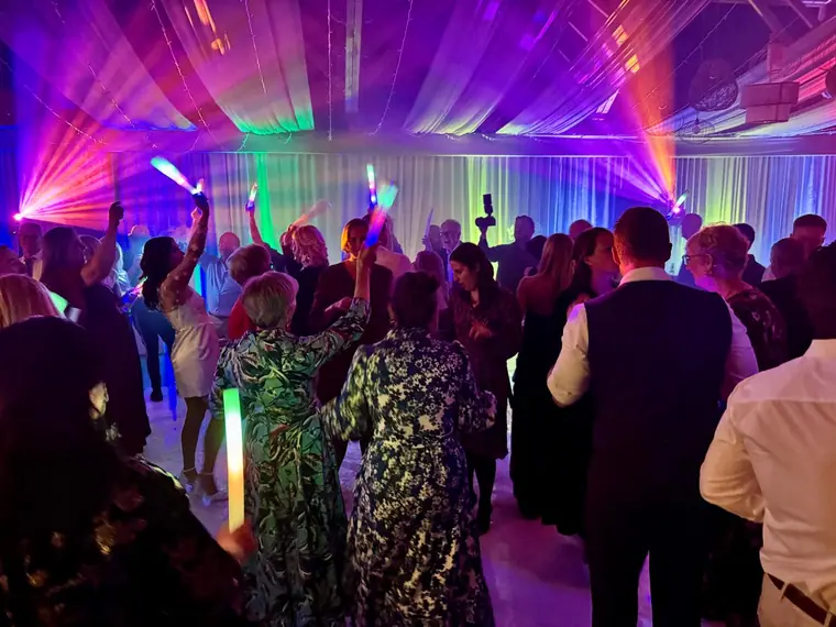 Packed marquee dancefloor under green and purple lighting