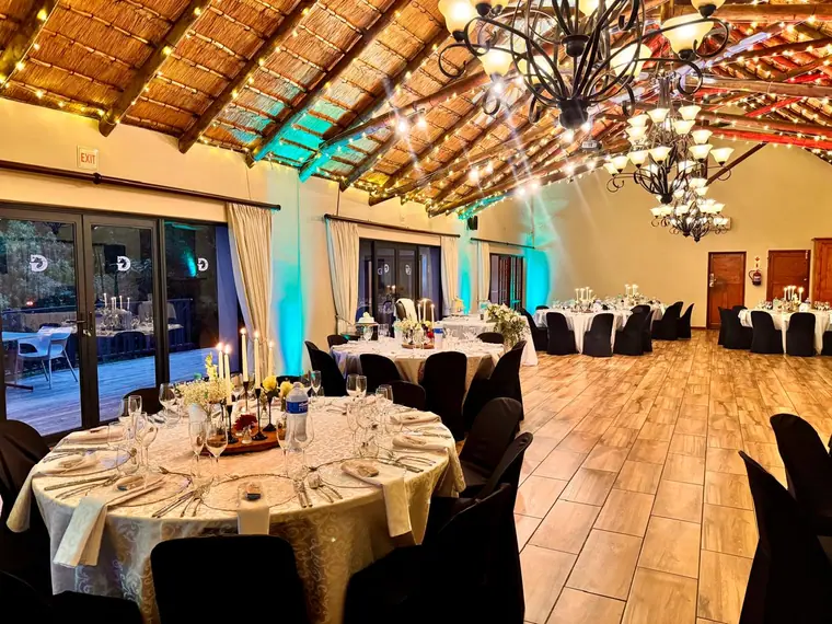 Reception tables set under the thatched roof at Granny Mouse