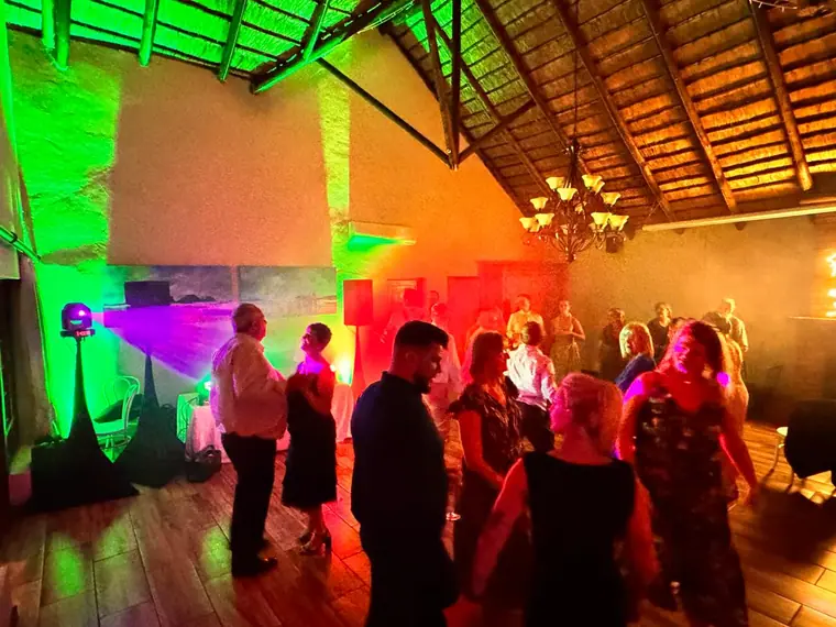 Dancefloor lit red and green beneath the thatch at Granny Mouse