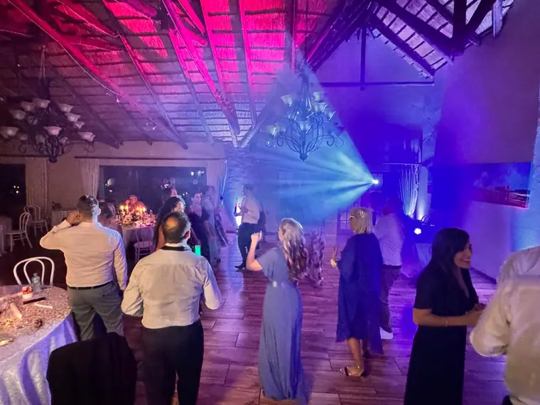 Guests dancing under a blue beam at a Granny Mouse wedding