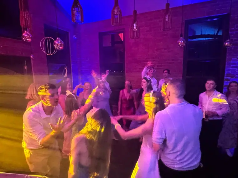 Wedding guests dancing under the cage pendants at Highgate Wine Estate