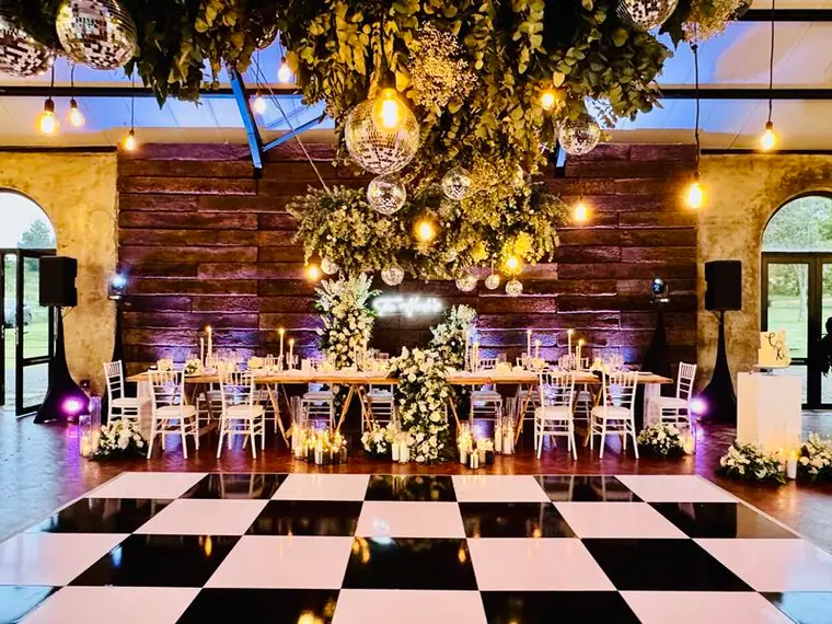 Reception room at Netherwood Farm with a checkerboard dancefloor and hanging greenery