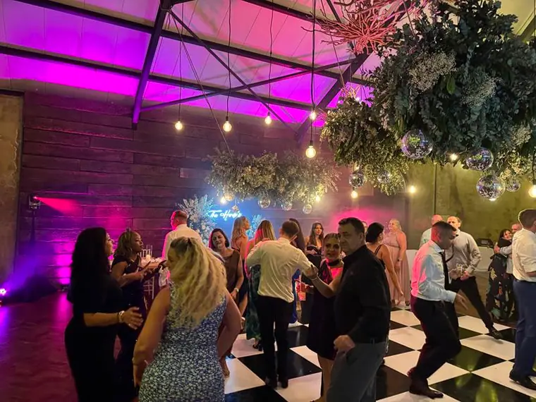 Dancing on the checkerboard floor under greenery at Netherwood Farm